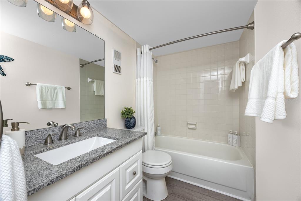 1300 Gulf Boulevard, Unit 301 Indian Rocks Beach, FL 33785 - Photo 23 of 46 a bathroom with a granite countertop sink toilet and shower