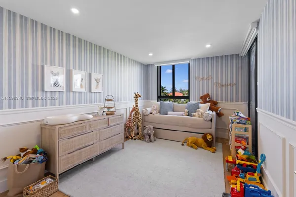 a living room with furniture and a baby crib