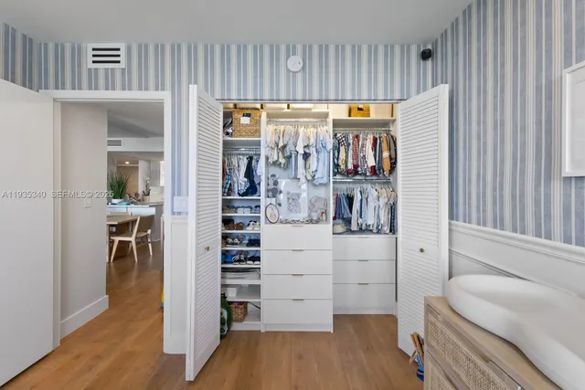 a view of walk in closet with wooden floor