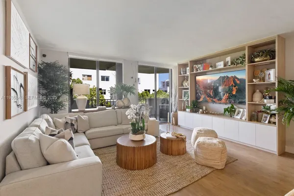 a living room with furniture a fireplace and a large window