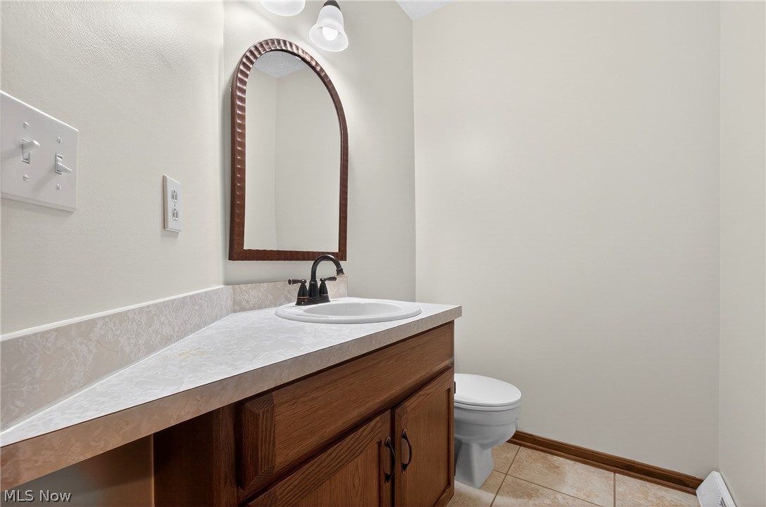 5346 Burlawn Street Northwest Canton, OH 44708 - Photo 20 of 40 Bathroom vanity featuring a rectangular sink, dark bronze faucet, and an arched mirror with a textured frame