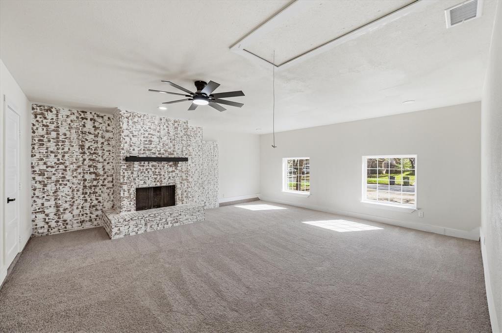 2804 Bent Tree Lane Arlington, TX 76016 - Photo 6 of 32 a view of a livingroom with a fireplace a ceiling fan and windows