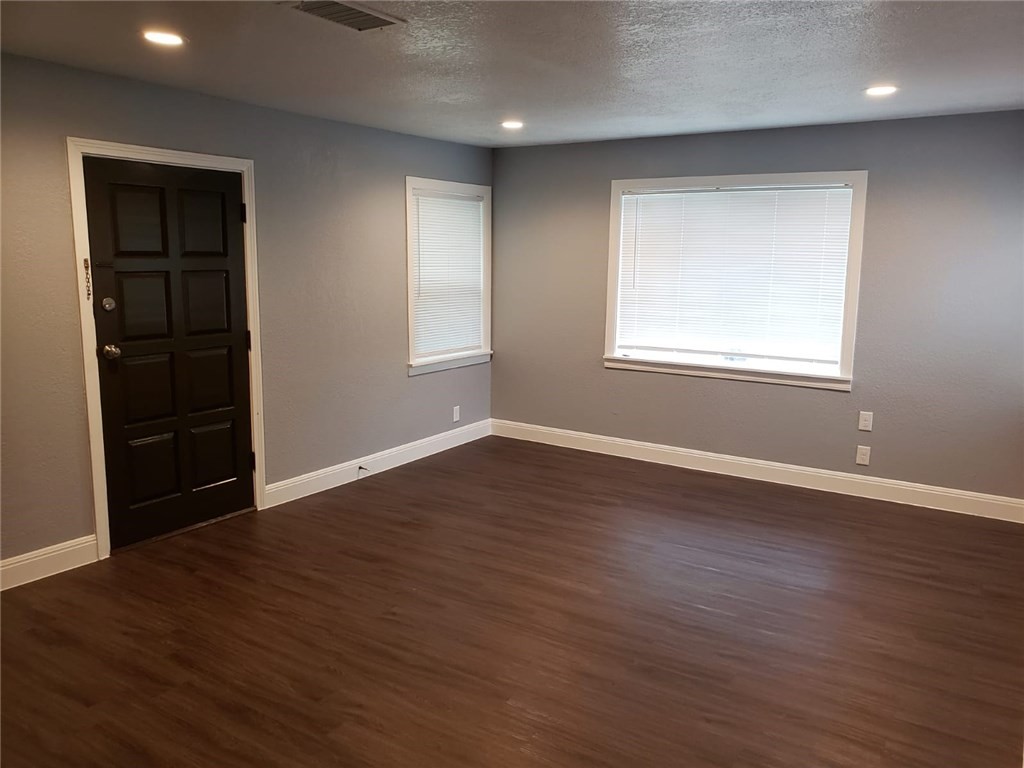 18901 Hogeye Road, Unit A Manor, TX 78653 - Photo 6 of 10 an empty room with wooden floor and windows