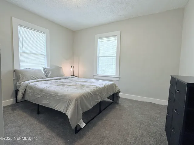 a spacious bedroom with a bed and a window