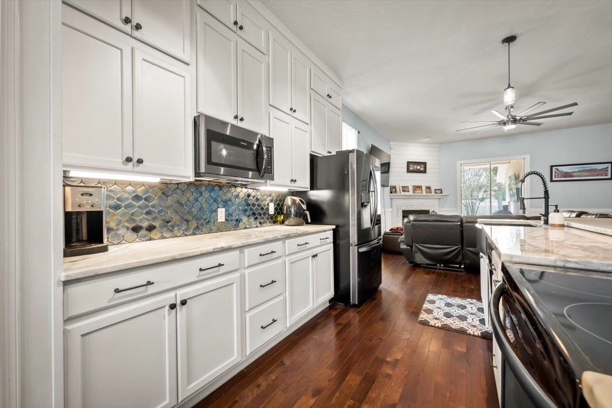 1701 Keswick Road St. Augustine, FL 32084 - Photo 13 of 57 a kitchen with a refrigerator a stove a sink dishwasher a oven with white cabinets and wooden floor