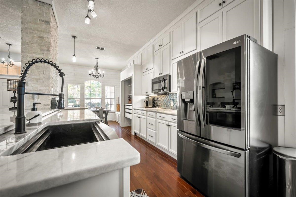 1701 Keswick Road St. Augustine, FL 32084 - Photo 3 of 57 a kitchen that has a refrigerator a sink and white cabinets