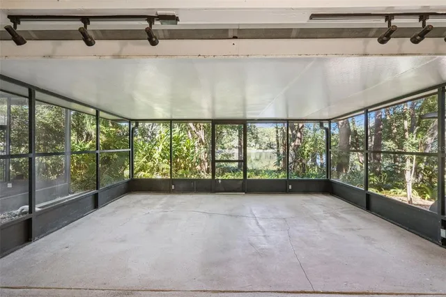 a backyard of a house with lots of plants and large trees