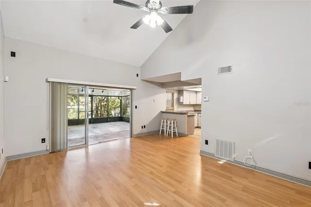 a view of an empty room with a window and wooden floor
