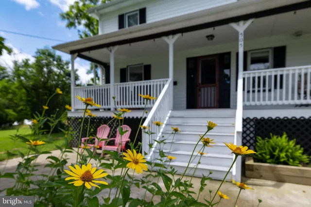 a view of a living room and dining room with furniture wooden floor and a chandelier