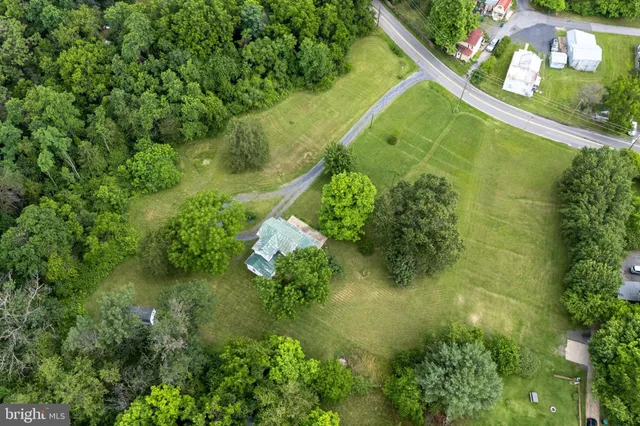 an aerial view of residential houses with outdoor space and trees