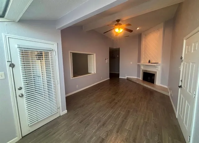 a view of a livingroom with wooden floor and a ceiling fan