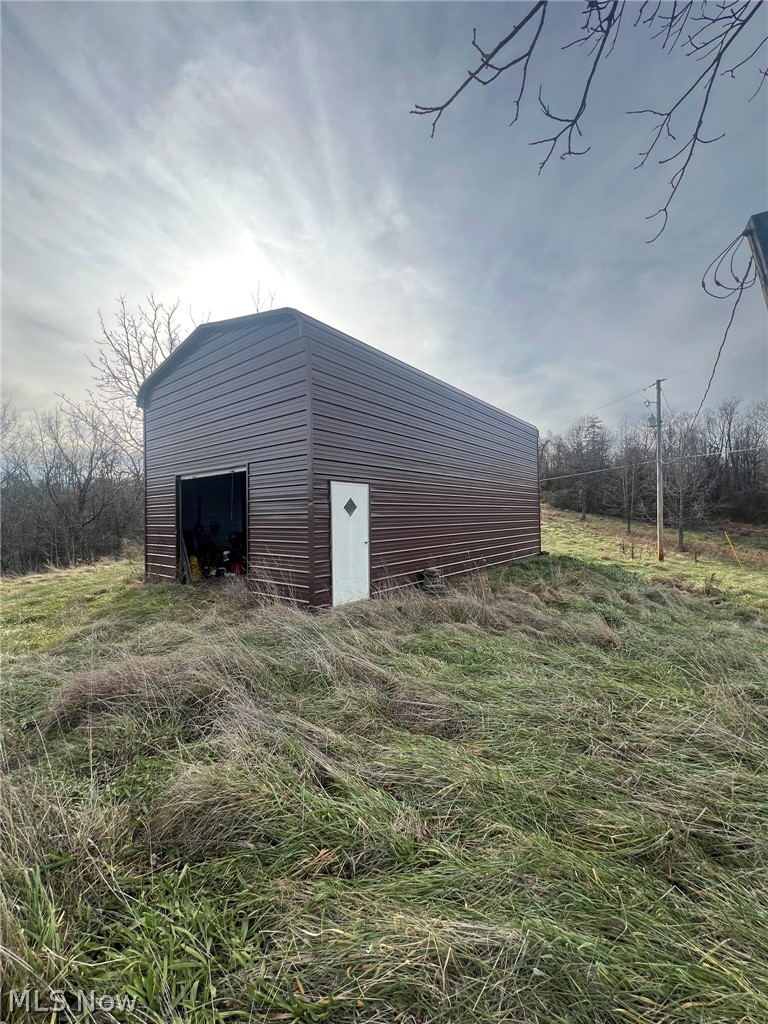 53720 Highway 681 Reedsville, OH 45772 - Photo 23 of 25 Freestanding metal structure with an arched roof, featuring a single access door and an open bay