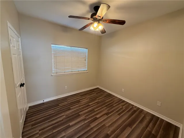 a bathroom with a toilet sink vanity granite and mirror