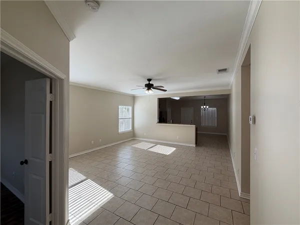 a view of a big room with windows and chandelier fan