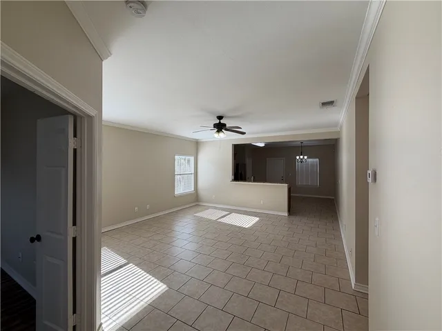 a view of a big room with windows and chandelier fan