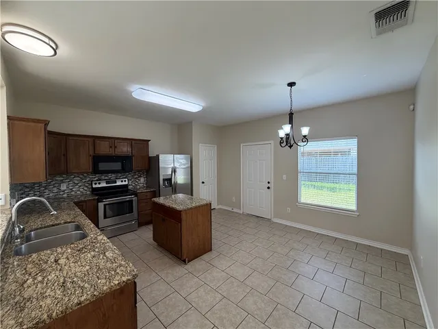 a kitchen with granite countertop wooden cabinets and stainless steel appliances