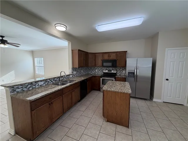 a view of a livingroom with a chandelier fan and windows
