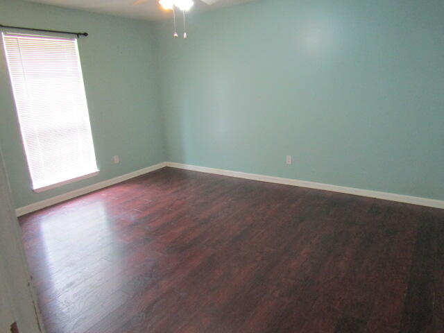 1112 Country Living Road Baker, FL 32531 - Photo 11 of 16 an empty room with wooden floor and windows
