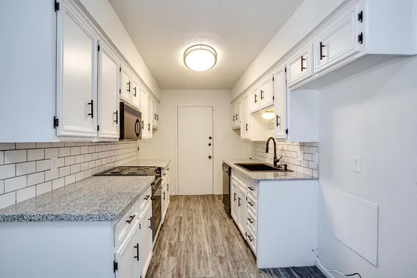 a kitchen with stainless steel appliances granite countertop a sink stove and cabinets