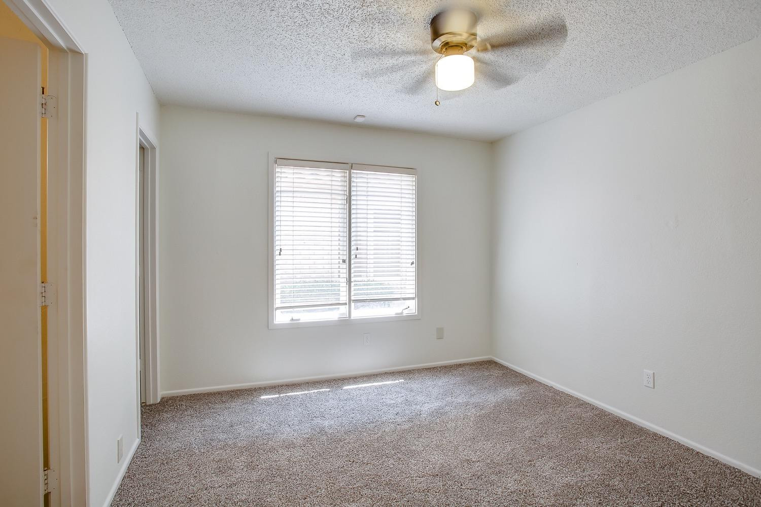 4749 2nd Street Lubbock, TX 79416 - Photo 10 of 13 an empty room with windows and a chandelier fan