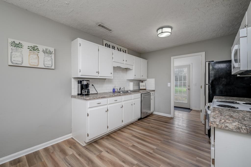 636 Crescent Road Murfreesboro, TN 37128 - Photo 6 of 22 a kitchen with granite countertop white cabinets and white appliances