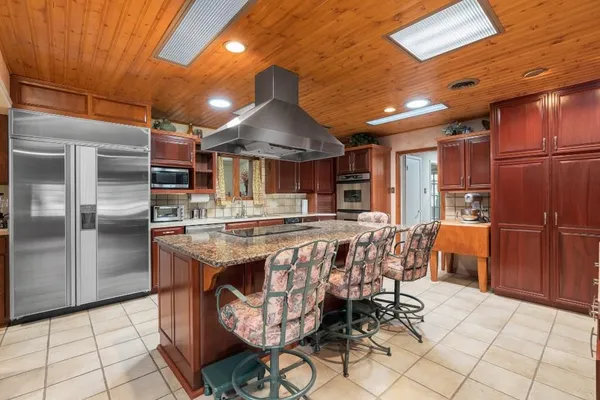 a kitchen with stainless steel appliances granite countertop a sink and a wooden cabinets