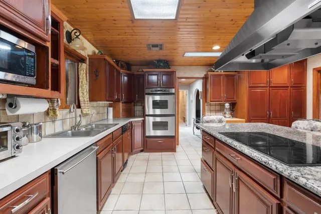 a kitchen with granite countertop a sink a stove and cabinets