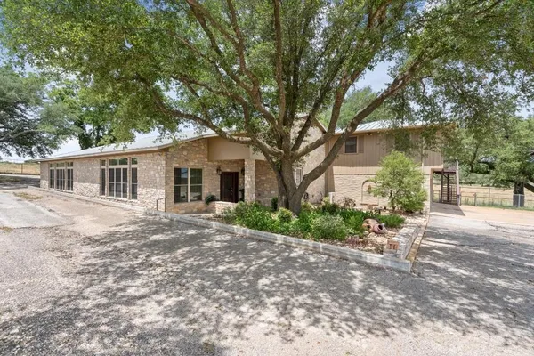 a front view of a house with a garden and yard