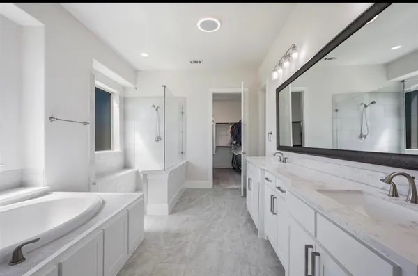 a bathroom with a granite countertop sink mirror and bathtub