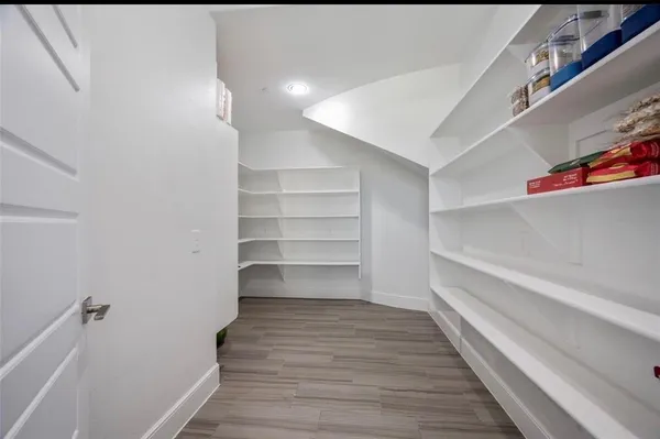 a dining room with wooden floor a chandelier a glass table and chairs