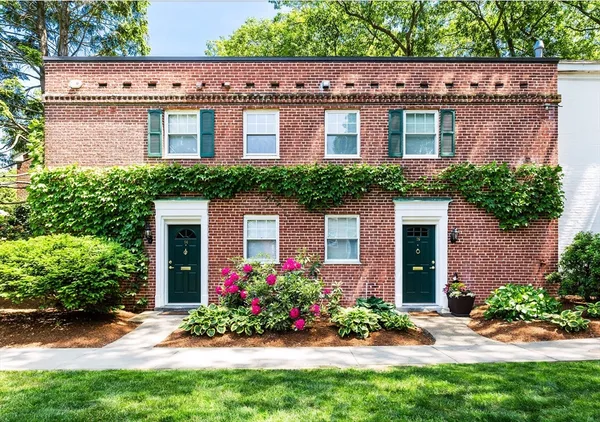 a front view of a house with a yard and potted plants