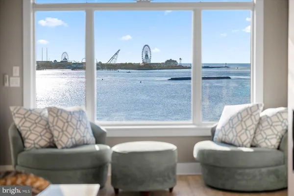 a kitchen with stainless steel appliances kitchen island granite countertop a dining table chairs sink and cabinets