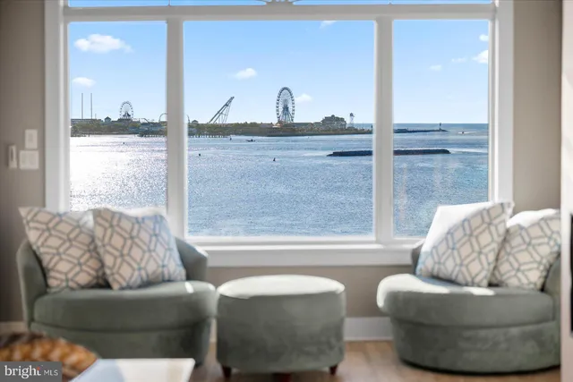 a kitchen with stainless steel appliances kitchen island granite countertop a dining table chairs sink and cabinets