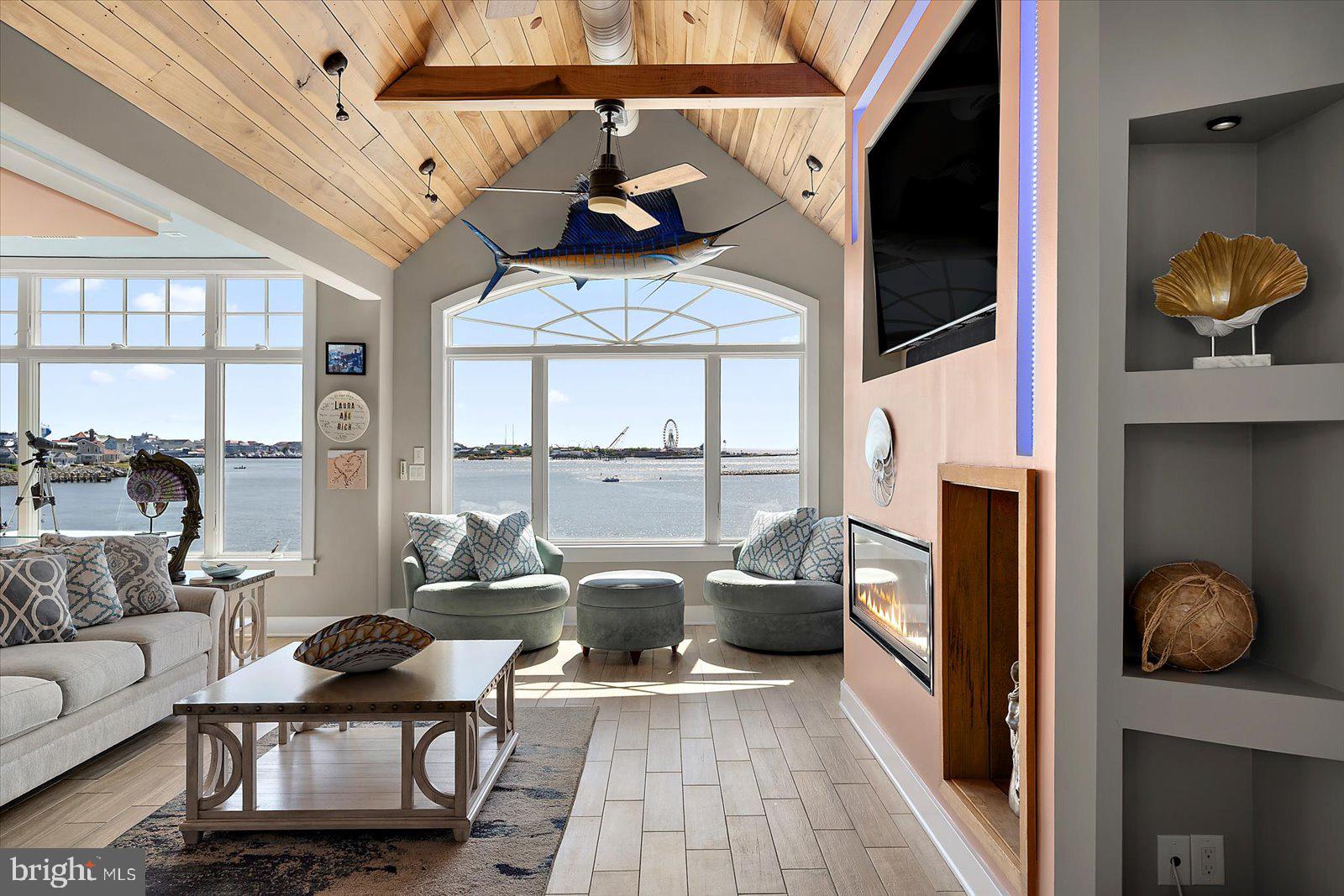 12957 Harbor Road Ocean City, MD 21842 - Photo 27 of 148 a living room with furniture a flat screen tv and a floor to ceiling window