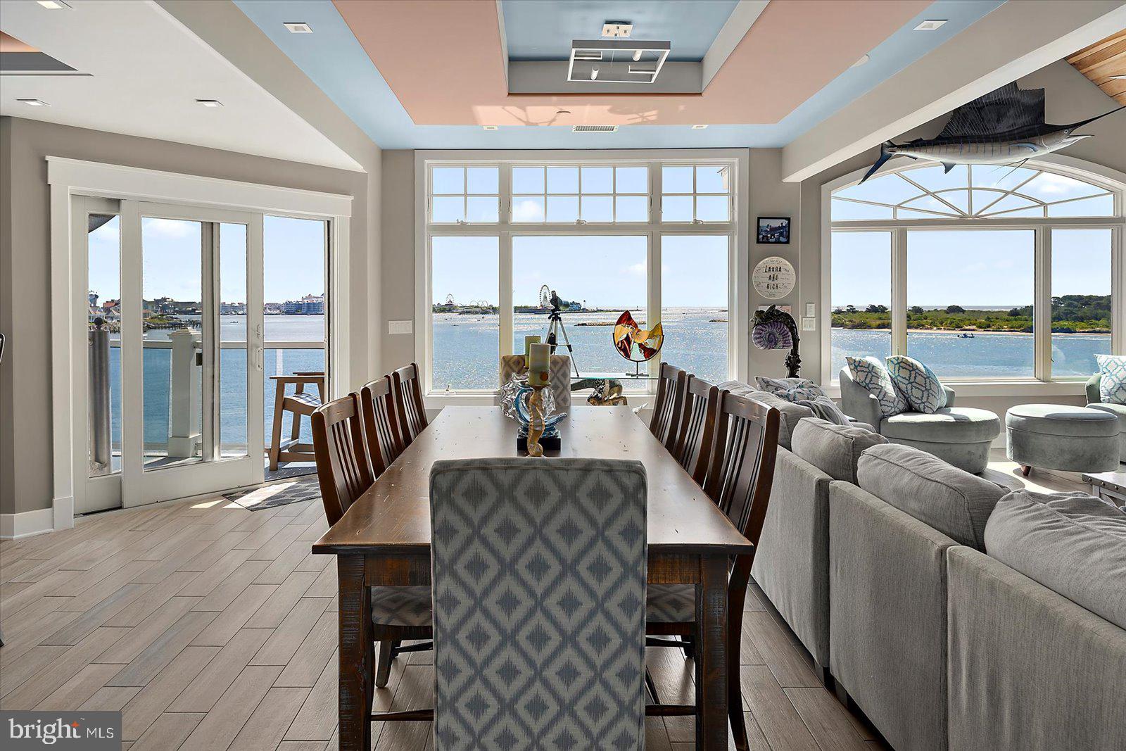 12957 Harbor Road Ocean City, MD 21842 - Photo 52 of 148 a view of a dining room with furniture large windows and wooden floor