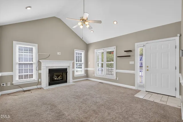 a view of an empty room with a fireplace and a window