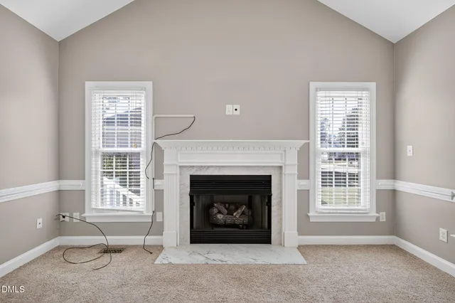 a living room with a fireplace and windows