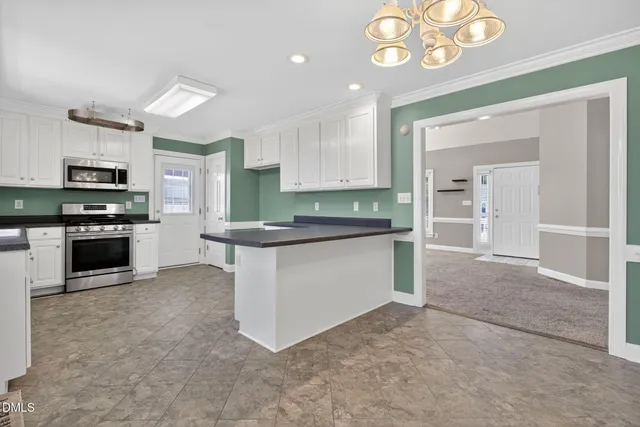 a kitchen with stainless steel appliances granite countertop a stove top oven a sink and a refrigerator