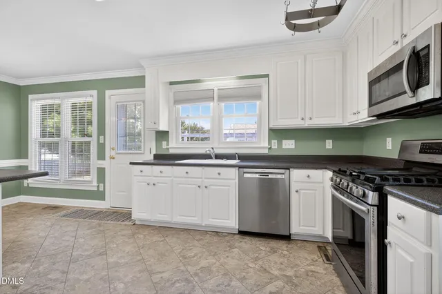 a kitchen with stainless steel appliances granite countertop a stove a sink and a microwave