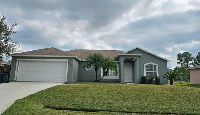 a front view of a house with a yard and garage