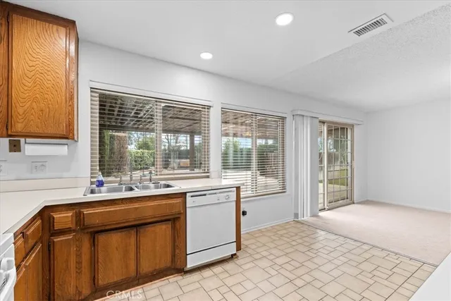 a view of kitchen with cabinets and window