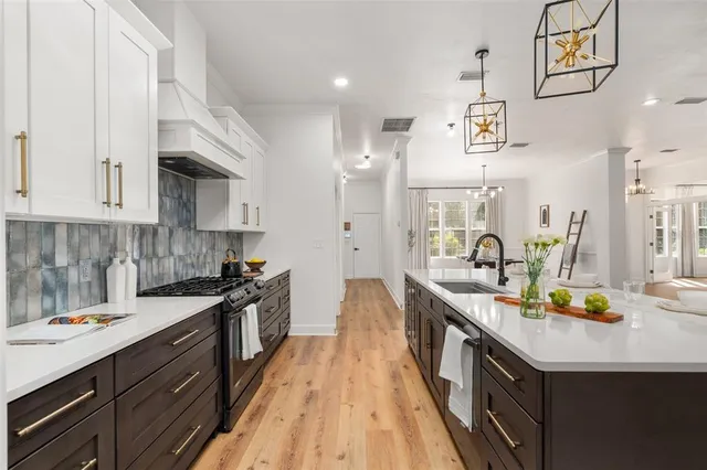 a kitchen with granite countertop a sink a counter space appliances and cabinets