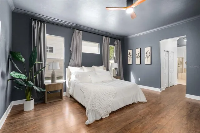 a bedroom with a large bed and a potted plant
