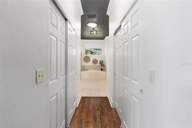 a view of a hallway with wooden floor and staircase