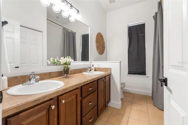 a bathroom with a sink double vanity granite and a mirror