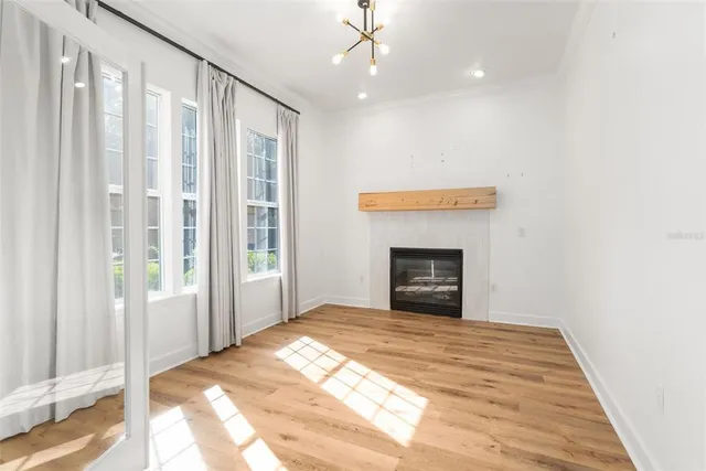 a view of an empty room with a fireplace and a window