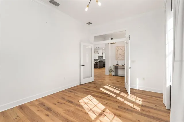 a view of a hallway with wooden floor and a bathroom