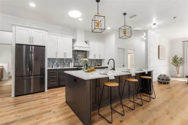 a kitchen with stainless steel appliances kitchen island granite countertop a sink and a refrigerator