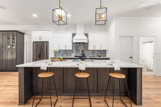 a kitchen with stainless steel appliances kitchen island granite countertop a dining table and chairs