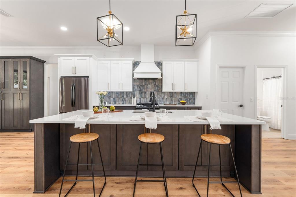 6326 Southwest 90th Street Gainesville, FL 32608 - Photo 9 of 44 a kitchen with stainless steel appliances kitchen island granite countertop a dining table and chairs